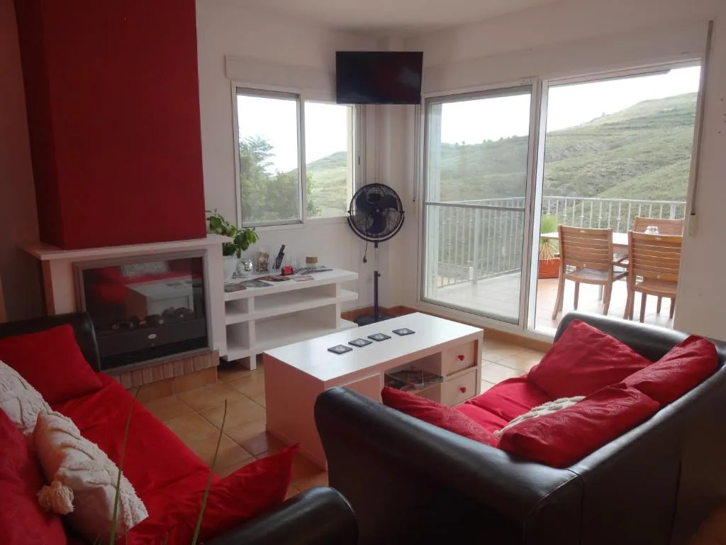 Salon avec canapés rouges et vue montagne